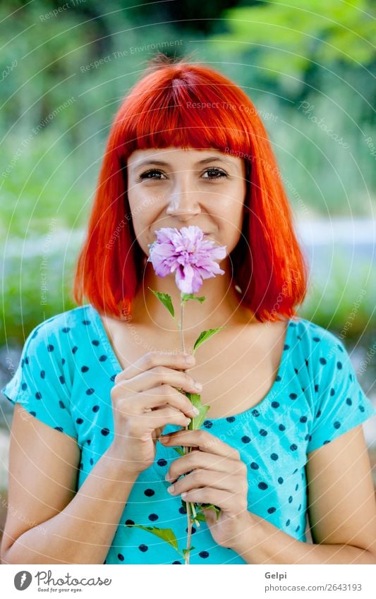 Rothaarige Frau, die eine Blume in einem Park riecht. Lifestyle Glück schön Gesicht Wellness Erholung Duft Sommer Garten Mensch Erwachsene Natur Baum Blüte Mode