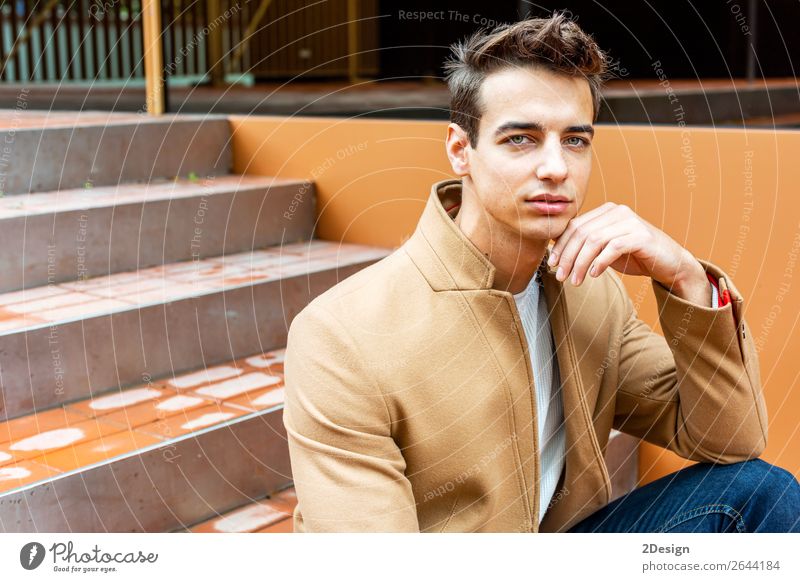 Junger Mann in Winterkleidung auf der Straße sitzend Lifestyle elegant Stil schön Haare & Frisuren Mensch Erwachsene Jugendliche Herbst Mode Bekleidung