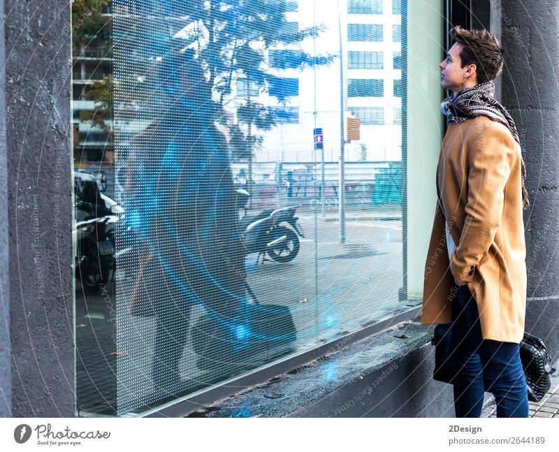 Junger Mann in Winterkleidung auf der Straße, der eine Ausstellung sucht. Lifestyle elegant Stil schön Haare & Frisuren Mensch Erwachsene Jugendliche Herbst