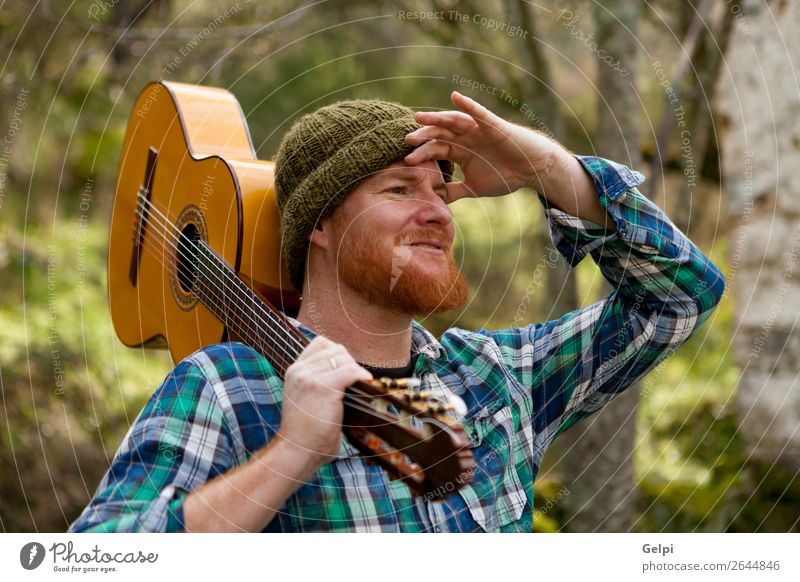 Hipster Mann hält eine Gitarre und schaut hin. Freizeit & Hobby Spielen Haus Entertainment Musik Mensch Erwachsene Musiker rothaarig Oberlippenbart Coolness