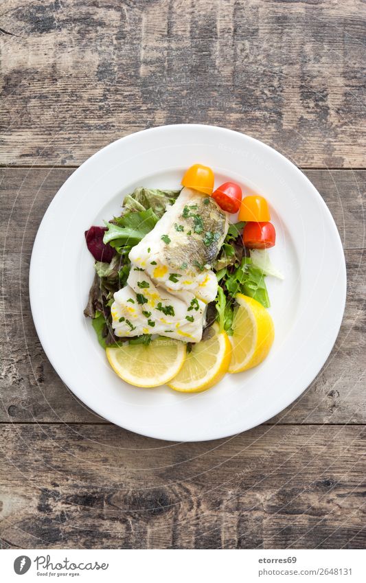 Gebratenes Kabeljaufilet und Salat auf Teller auf Holzuntergrund Dorsch Fisch Salatbeilage Lebensmittel Gesunde Ernährung Foodfotografie Speise Gesundheit