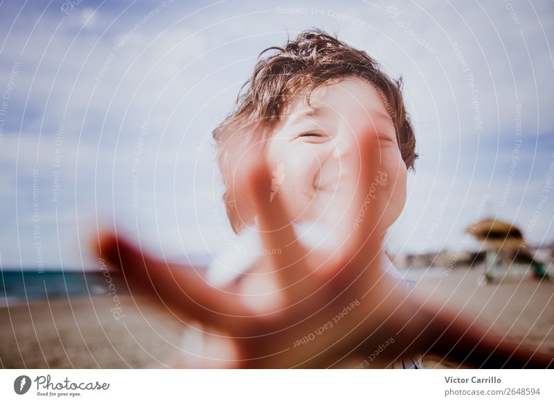 Ein lächelnder kleiner Junge an einem sonnigen Tag Mensch maskulin Baby Kopf 1 1-3 Jahre Kleinkind Medien Printmedien Wolken Strand Gefühle Stimmung