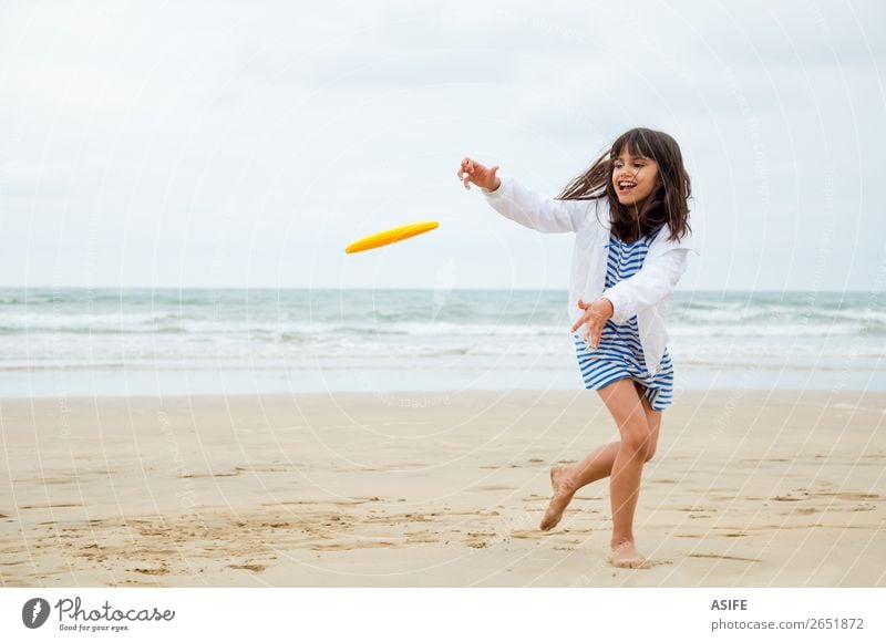 Gril beim Frisbee spielen Freude Glück schön Freizeit & Hobby Spielen Strand Wellen Sport Kind Sand Wolken Küste Kleid niedlich blau gelb Aktion Mädchen