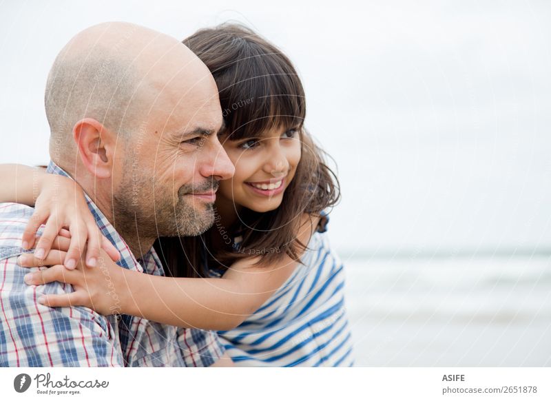 Vater und Tochter schauen nach vorne Freude Glück schön Strand Meer Kind Eltern Erwachsene Familie & Verwandtschaft Wolken Glatze Lächeln lachen Liebe Umarmen