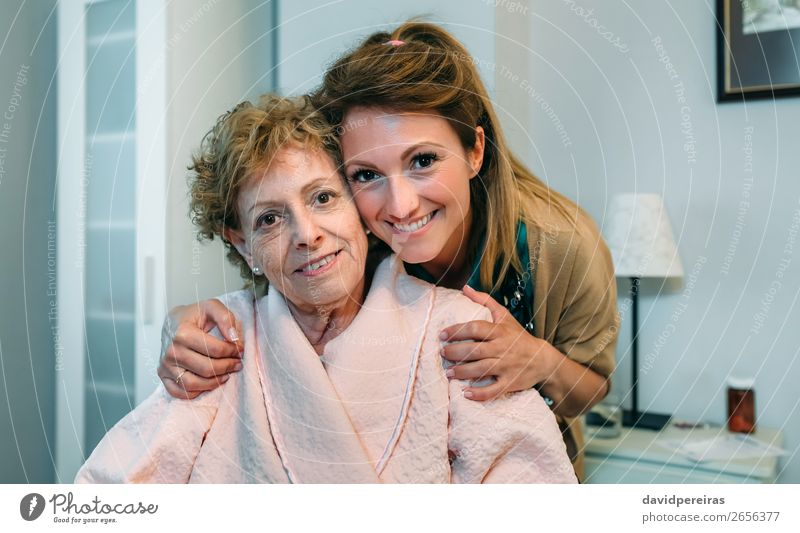 Weibliche Betreuerin posiert mit älterer Patientin Glück Gesundheitswesen Krankheit Lampe Schlafzimmer Arzt Krankenhaus Mensch Frau Erwachsene alt Lächeln