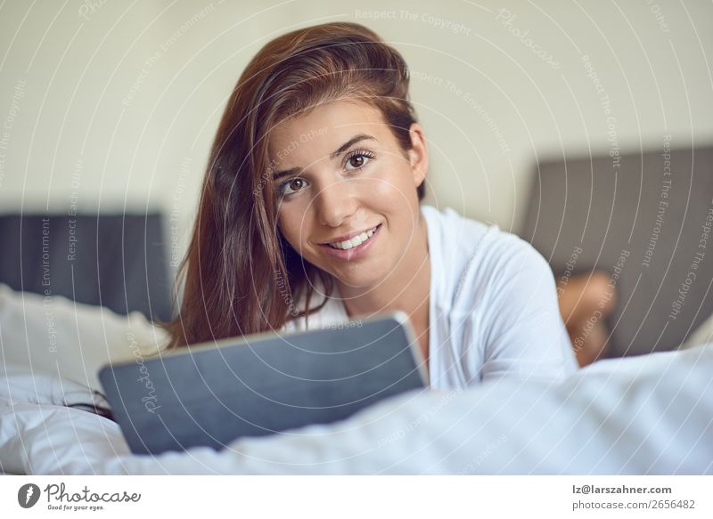 Hübsche junge Frau mit Tablette im Bett kaufen Glück schön Schlafzimmer Business Computer Technik & Technologie Internet Erwachsene 1 Mensch 18-30 Jahre