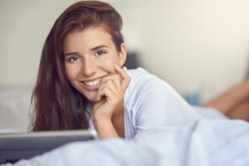 Hübsche junge Frau mit Tablette im Bett kaufen Glück schön Schlafzimmer Business Computer Technik & Technologie Internet Erwachsene 1 Mensch 18-30 Jahre