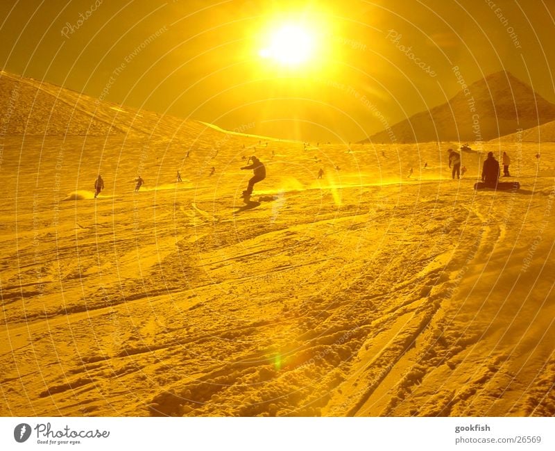 schnellschnee Snowboard gelb Aktion Sport Schnee Sonne Gelbstich Gegenlicht Sonnenstrahlen Skipiste Skigebiet Snowboarder Snowboarding Schwung abwärts viele