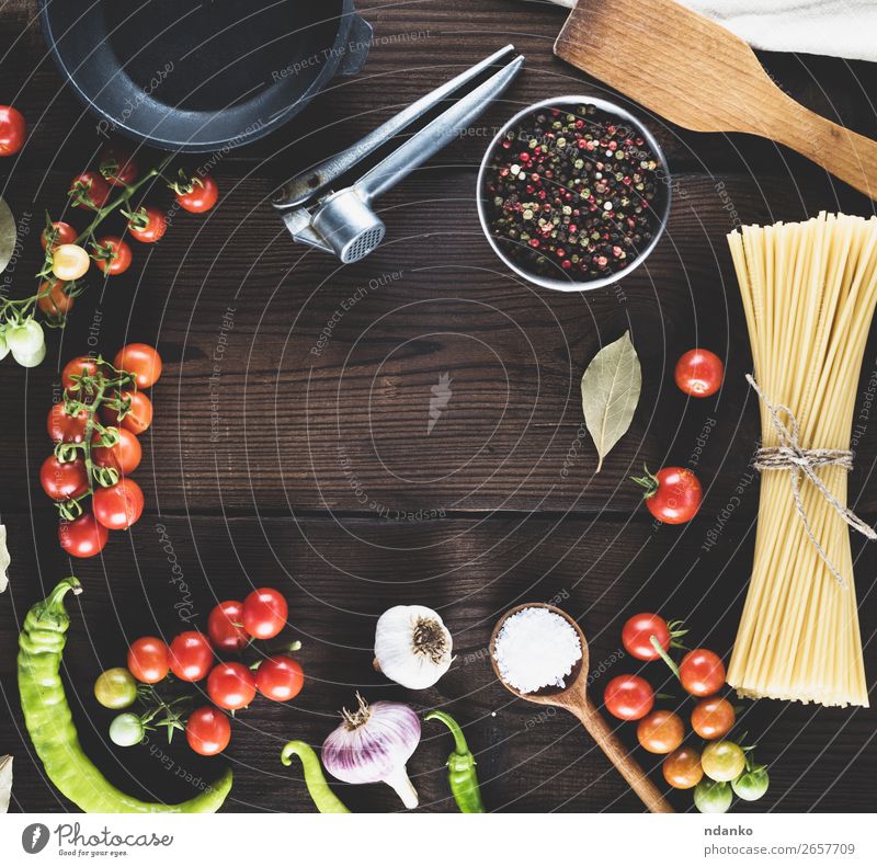 Nudeln roh mit Seil gebunden Gemüse Teigwaren Backwaren Kräuter & Gewürze Pfanne Löffel Tisch Küche Holz Linie frisch groß lang oben braun gelb rot schwarz