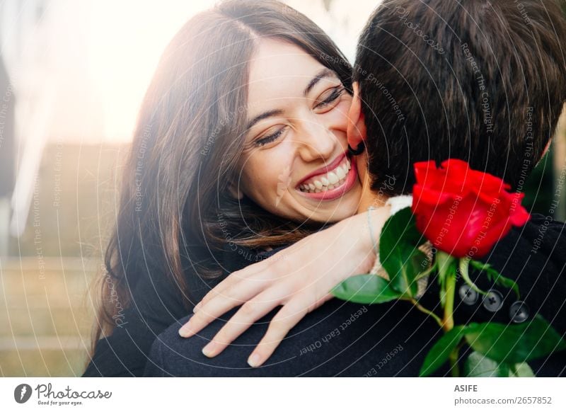Ein glückliches Paar, das in eine Rose verliebt ist. Freude Glück schön Winter Feste & Feiern Valentinstag Frau Erwachsene Mann Hand Herbst Blume Mantel Küssen