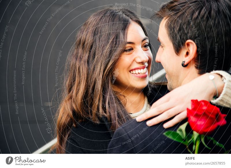 Ein glückliches Paar, das in eine Rose auf der Straße verliebt ist. Freude Glück schön Winter Feste & Feiern Valentinstag Frau Erwachsene Mann Hand Herbst Blume