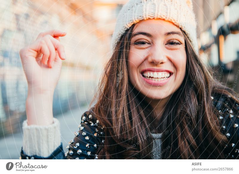 Lachendes Mädchen mit Wollmütze Freude Glück schön Gesicht Winter Mensch Frau Erwachsene Jugendliche Herbst Wärme Mode brünett genießen Lächeln lachen