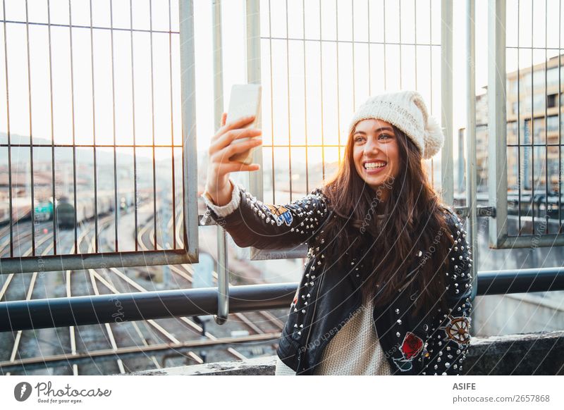 Selfie Mädchen in der Stadt bei Sonnenuntergang Glück schön Winter PDA Technik & Technologie Frau Erwachsene Jugendliche Herbst Bahnhof Straße Gleise Mode