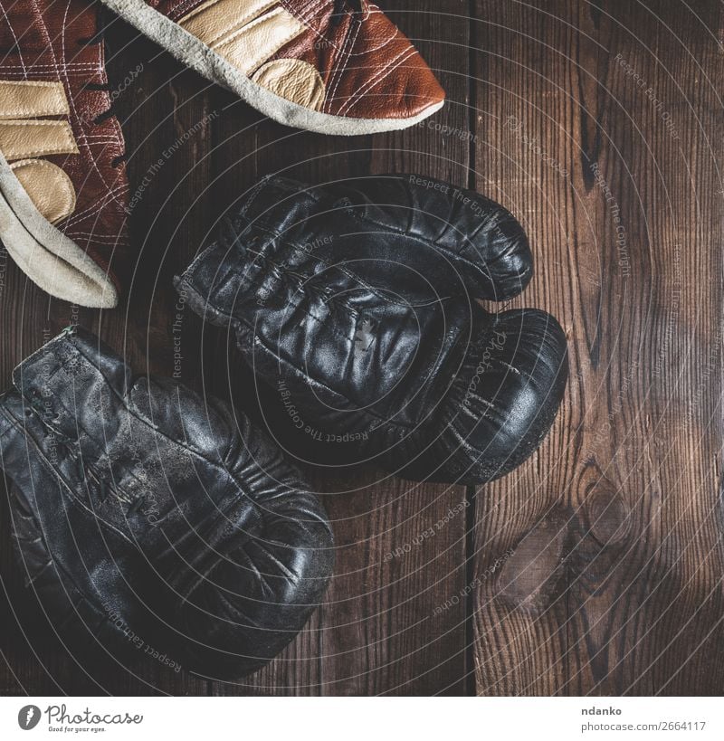 Paar sehr alte schwarze Boxhandschuhe aus Leder Lifestyle Fitness Sport Erfolg Handschuhe Schuhe Holz dunkel retro braun Schutz Konkurrenz Nutzholz rustikal