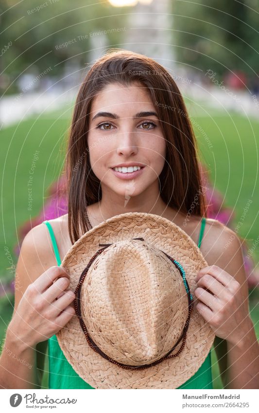Porträt einer jungen glücklichen Frau im Park Lifestyle Glück schön Ferien & Urlaub & Reisen Tourismus Sommer Mensch Erwachsene Natur Straße Mode Hut Lächeln
