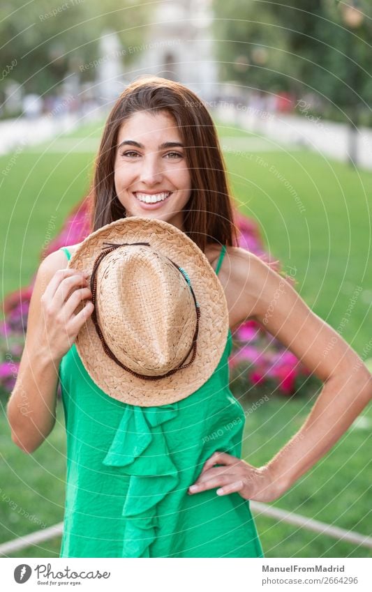 Porträt einer jungen glücklichen Frau im Park Lifestyle Glück schön Ferien & Urlaub & Reisen Tourismus Sommer Mensch Erwachsene Natur Straße Mode Hut Lächeln
