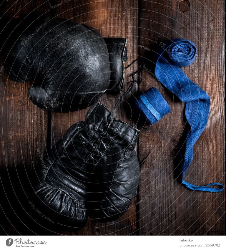 Paar sehr alte schwarze Boxhandschuhe aus Leder Lifestyle Fitness Sport Seil Ring Handschuhe Holz retro blau braun Schutz Konkurrenz Macht Kraft Stil Aktion