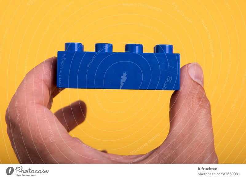 Spiel-Baustein in der Hand Finger Spielzeug Kunststoff wählen bauen berühren festhalten blau Optimismus Erfolg Idee Teamwork zusammenbauen Teile u. Stücke