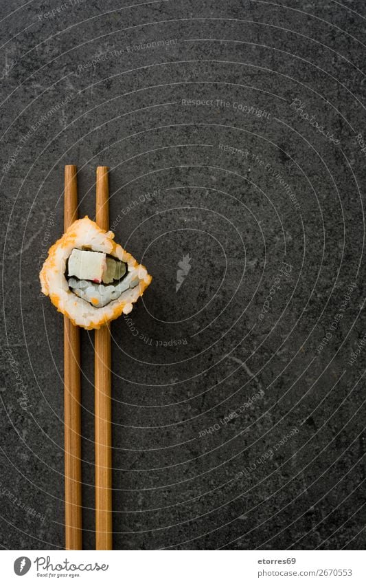 Essstäbchen mit Sushi auf schwarzem Stein. Lebensmittel Gesunde Ernährung Foodfotografie Japanisch Reis Fisch Lachs Meeresfrüchte Brötchen Mahlzeit machen