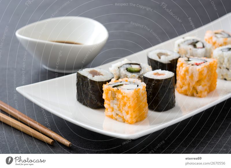 Sushi-Sortiment in weißer Platte auf schwarzem Hintergrund Lebensmittel Gesunde Ernährung Foodfotografie Japanisch Reis Fisch Lachs Meeresfrüchte Brötchen