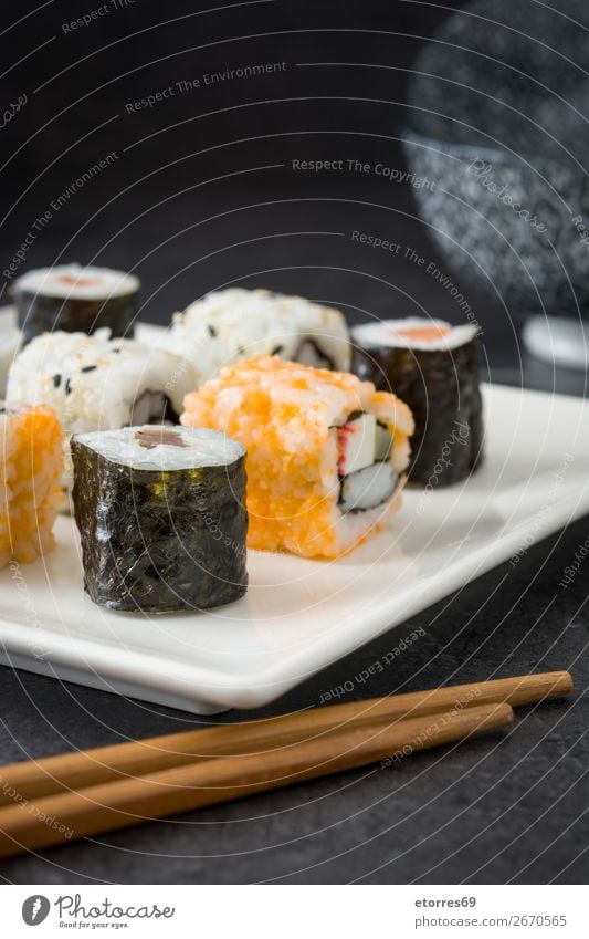 Sushi-Sortiment in weißer Platte auf schwarzem Hintergrund Lebensmittel Gesunde Ernährung Foodfotografie Japanisch Reis Fisch Lachs Meeresfrüchte Brötchen