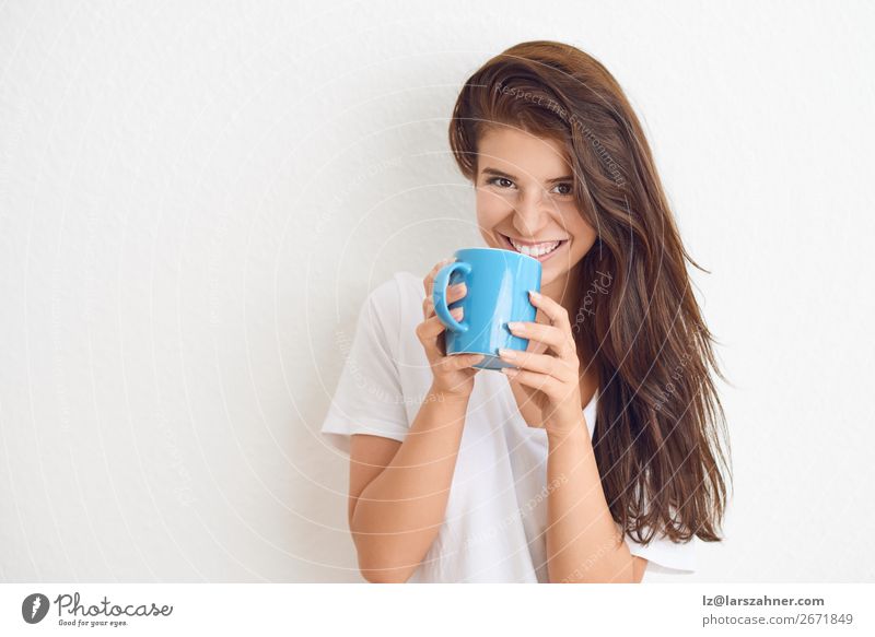 Lächelnde Frau trinkt Kaffee aus dem blauen Becher. Getränk trinken Tee Glück Gesicht Erwachsene 1 Mensch 18-30 Jahre Jugendliche schreien Fröhlichkeit heiß