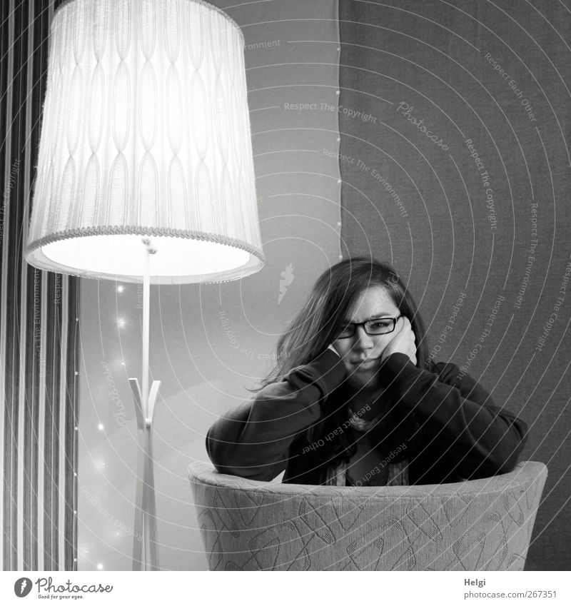 junge Frau mit langen Haaren stützt den Kopf in die Hände Häusliches Leben Wohnung Innenarchitektur Dekoration & Verzierung Möbel Lampe Sessel Tapete Raum