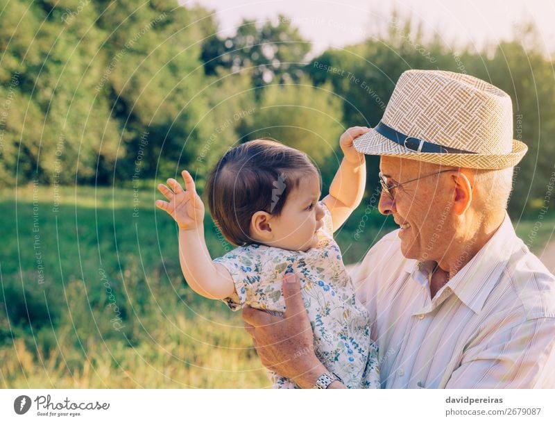 Baby-Mädchen spielt mit Hut des älteren Mannes Lifestyle Glück Erholung Spielen Sommer Mensch Kleinkind Frau Erwachsene Eltern Großvater