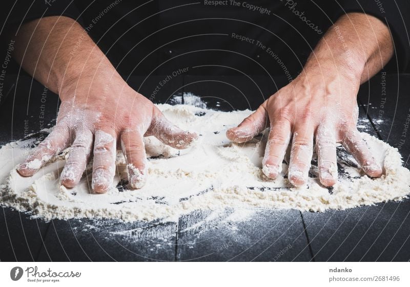 weißes Weizenmehl auf einem schwarzen Holztisch Teigwaren Backwaren Brot Tisch Küche Koch Mensch Mann Erwachsene Hand machen dunkel Mehl Küchenchef Pizza