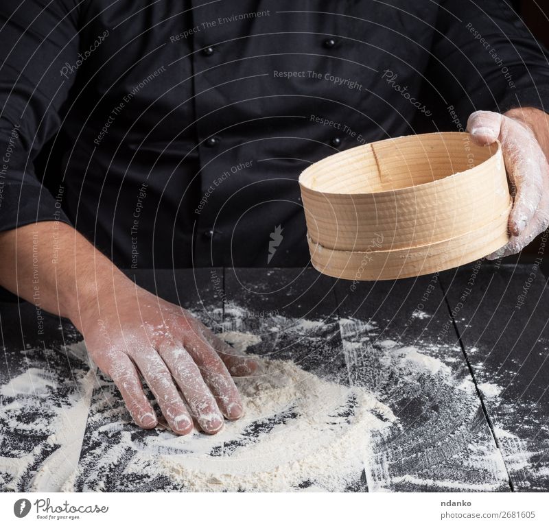 Der Koch bereitet den Teig aus Weißmehl zu. Teigwaren Backwaren Brot Ernährung Tisch Küche Mann Erwachsene Hand Sieb Holz dunkel natürlich weiß Mehl