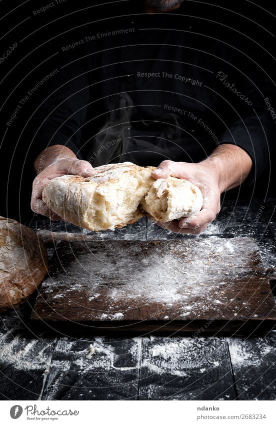 gebackenes Brot Ernährung Tisch Küche Koch Mensch Hand 30-45 Jahre Erwachsene Holz machen dunkel frisch heiß braun schwarz weiß Tradition Bäcker Bäckerei