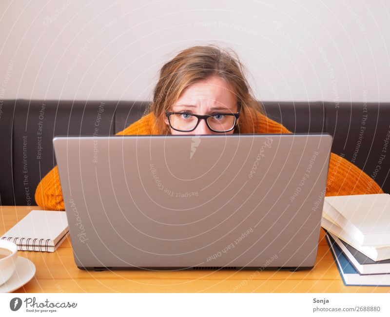 Junge verzweifelte Studentin mit Brille blickt über einen Laptop Lifestyle lernen Notebook Informationstechnologie feminin Junge Frau Jugendliche 1 Mensch