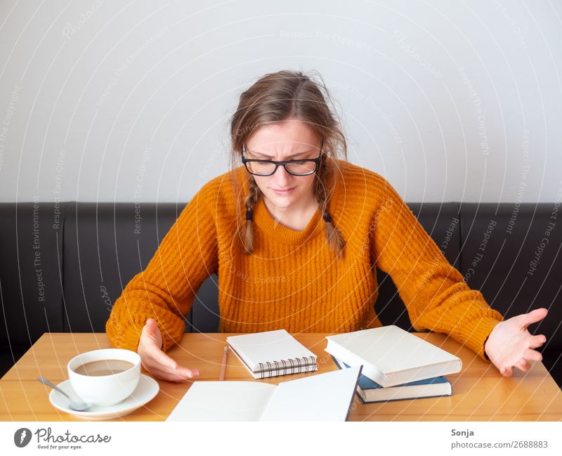 Verzweifelte Studentin vor einem aufgeschlagenen Buch Kaffee Lifestyle lernen feminin Junge Frau Jugendliche 1 Mensch 18-30 Jahre Erwachsene Pullover Zopf