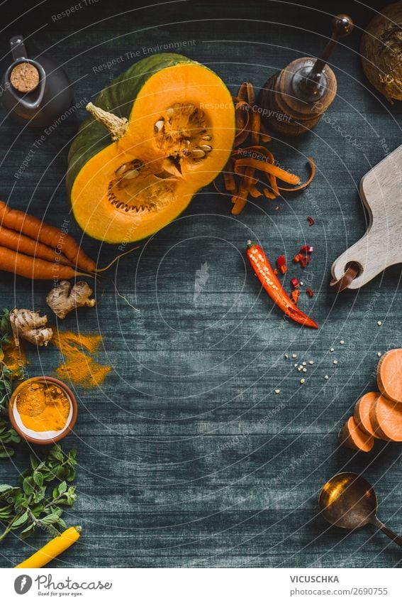 Lebensmittelhintergrundrahmen mit Kürbis und orangefarbenem Gemüse auf dem Küchentisch, Draufsicht. Herbstliches Kochen Hintergrund Rahmen Farbe Tisch Top