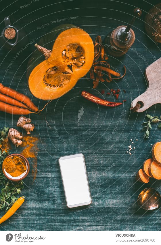Smartphone auf Küchentisch mit Kürbis Lebensmittel Gemüse Ernährung Bioprodukte Vegetarische Ernährung Diät Geschirr kaufen Design Gesunde Ernährung Tisch PDA