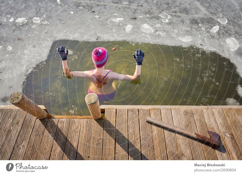Fit Frau führt Eisschwimmen im Eisloch durch. Lifestyle Gesundheit Alternativmedizin sportlich Schwimmen & Baden Freizeit & Hobby Abenteuer Winter Wintersport