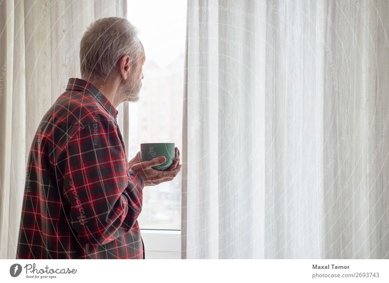 Ein erwachsener Mann trinkt seinen Kaffee und schaut aus dem Fenster. trinken Tee Mensch Erwachsene Stadt beobachten Denken stehen warten grün rot weiß