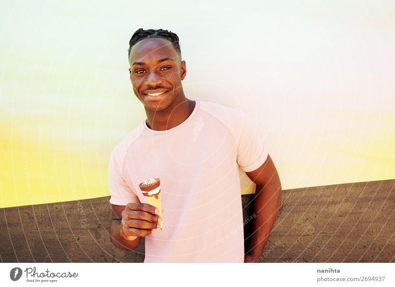 Ein junger, gutaussehender schwarzer Mann hält ein Eis. Lebensmittel Dessert Speiseeis Ernährung Essen Fastfood Stil Glück Sommer Sonnenbad Mensch maskulin