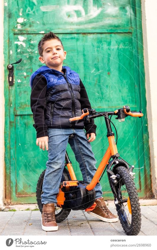 Kleiner Junge auf seinem Fahrrad auf der Motorhaube Lifestyle Freude Spielen Sportler Fahrradfahren Kind Schule Schulkind Mensch Baby Kleinkind Mann Erwachsene