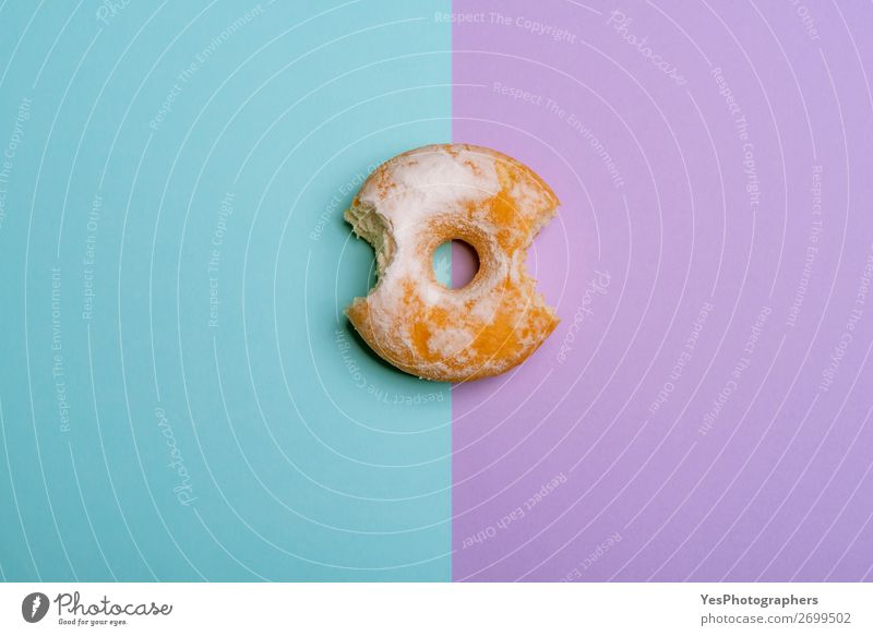 Bitten Donut auf blau-violettem, zweifarbigem Hintergrund Dessert Frühstück rosa obere Ansicht backen Bäckerei Biss gebissen Kuchen Konfekt Textfreiraum Krapfen