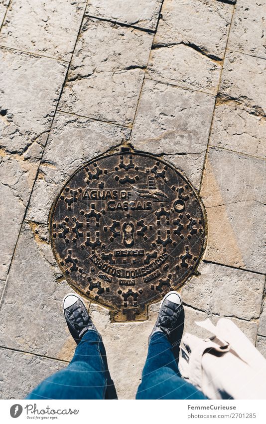 Woman stands on manhole cover in Cascais feminin 1 Mensch Ferien & Urlaub & Reisen Gully Portugal Symbole & Metaphern Turnschuh Jeanshose Tourismus Urlaubsfoto