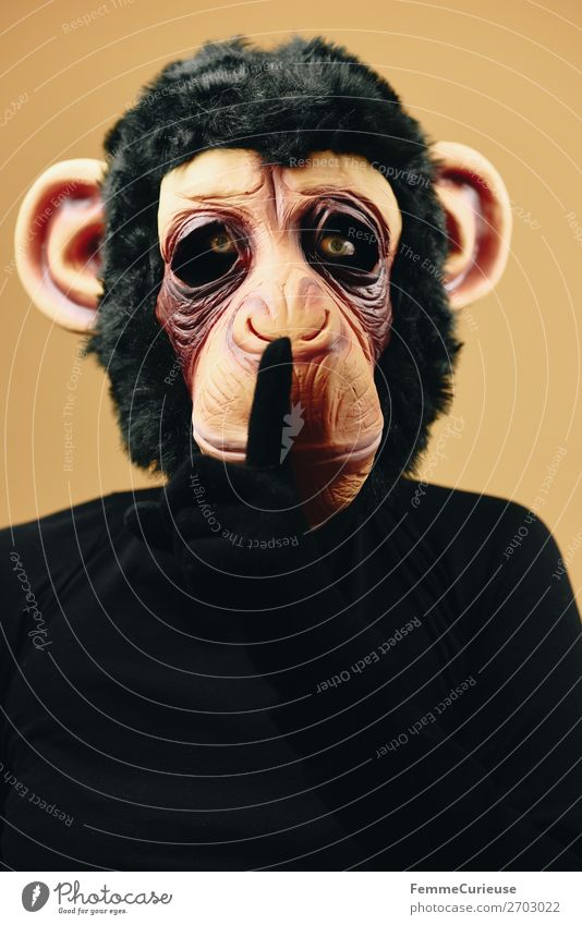 Person with monkey mask making psst gesture 1 Mensch Freude gestikulieren ruhig auffordern leise sein Maske Affen geheimnisvoll Schimpansen Karneval
