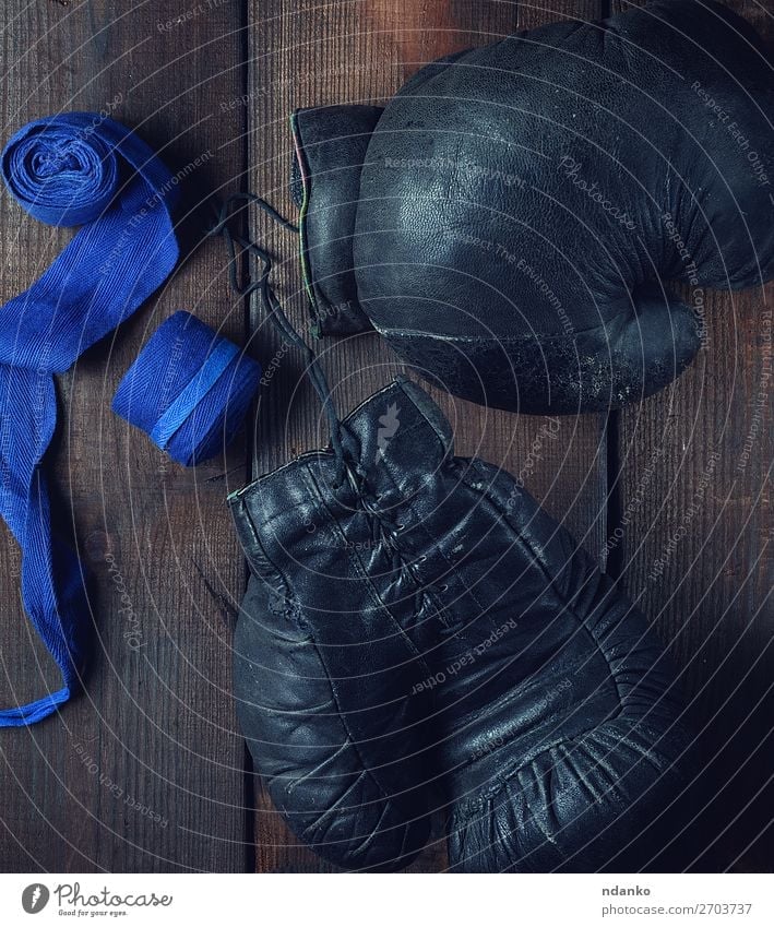 Paar sehr alte schwarze Boxhandschuhe aus Leder Lifestyle Fitness Sport Erfolg Seil Accessoire Ring Handschuhe Holz retro blau braun Schutz Konkurrenz Textil