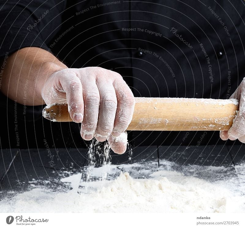 Koch hält ein hölzernes Nudelholz in der Hand. Teigwaren Backwaren Brot Tisch Küche Arbeit & Erwerbstätigkeit Mensch Holz gebrauchen machen frisch schwarz
