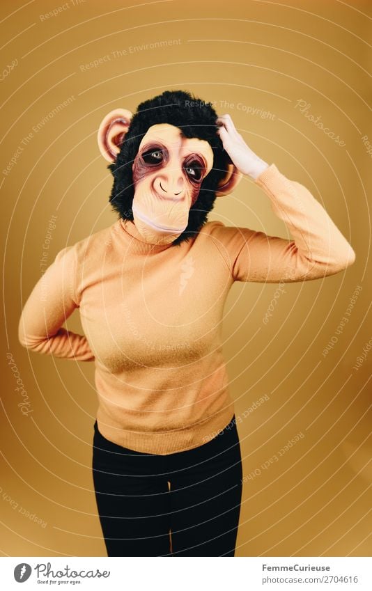 Woman with monkey mask scratching her head feminin Frau Erwachsene 1 Mensch 18-30 Jahre Jugendliche 30-45 Jahre Kommunizieren Evolution Menschlichkeit kratzen