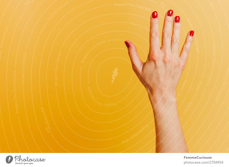 Forearm and hand with spread fingers against a yellow background feminin Frau Erwachsene 1 Mensch Nagellack rot gelb Finger Hand Gelenk Handoberfläche