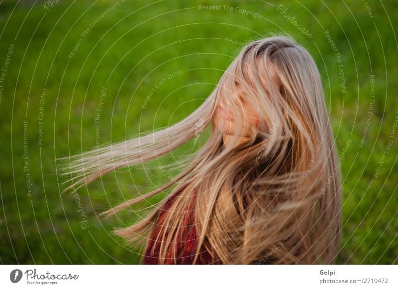 Hübsches blondes Mädchen mit einem schönen langen Lifestyle Stil Glück Haare & Frisuren Gesicht Mensch Frau Erwachsene Natur Wind Gras Park Mode Lächeln Erotik