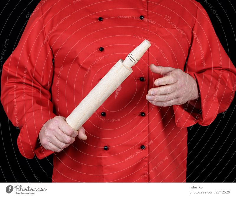 in einer roten Uniform kochen, die einen Holznudel hält. Küche Restaurant Arbeit & Erwerbstätigkeit Beruf Koch Mensch Mann Erwachsene Hand Bekleidung Hemd Anzug
