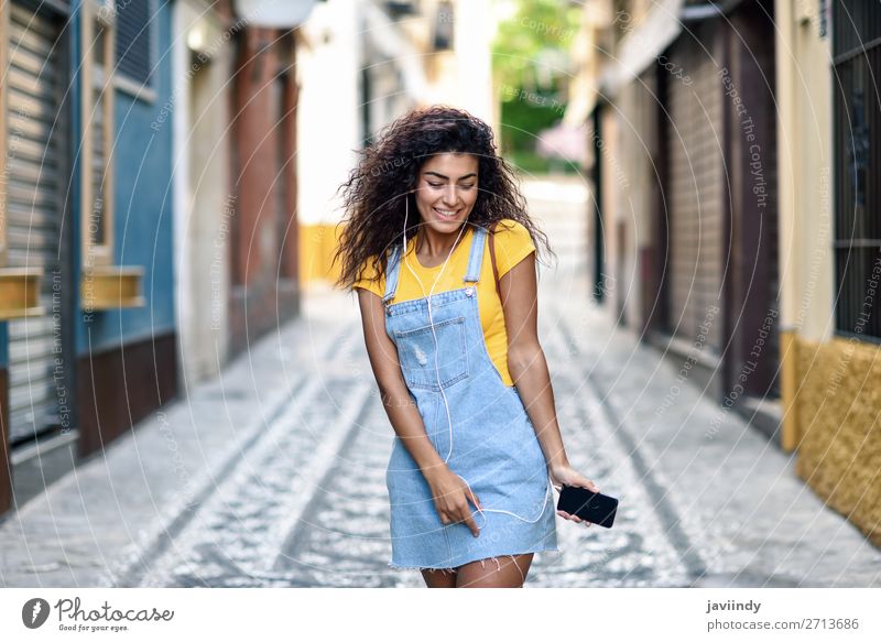Junge arabische Frau beim Musikhören mit Kopfhörern im Freien Lifestyle Stil Glück schön Haare & Frisuren Telefon PDA Technik & Technologie Mensch feminin