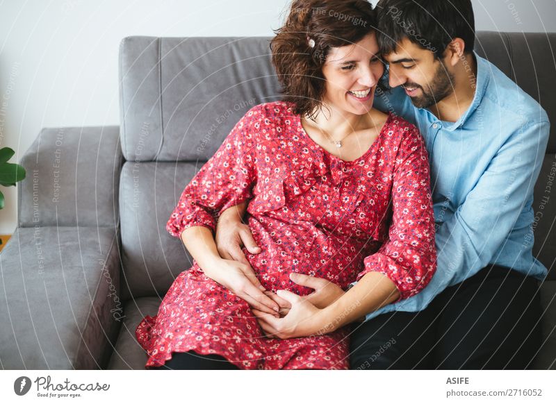 Liebende glückliche schwangere Paare zu Hause Glück schön Körper Baby Frau Erwachsene Mann Eltern Mutter Vater Familie & Verwandtschaft Blume Kleid berühren